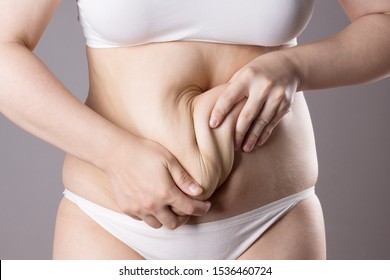 Flabby belly after pregnancy, overweight female body on gray background, studio shot - Shutterstock ID 1536460724