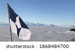 The flag of Antarctic flies above the Ross Ice Shelf near McMurdo Station, Antarctica
