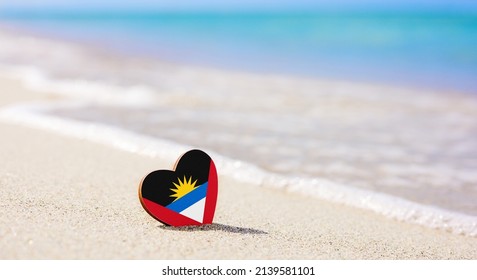 Flag Of Antigua And Barbuda In The Shape Of A Heart On A Sandy Beach. The Concept Of The Best Vacation In Antigua And Barbuda