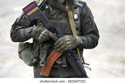 Flag of Armenia on submachine gun butt. Military Conflict in the Caucasus. Collage. 