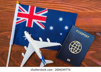 Flag Of Australia With Passport And Toy Airplane On Wooden Background. Flight Travel Concept 