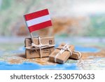 Flag of Austria near the parcels on the world map. World trade. Exports and imports of goods. Economy of the country.