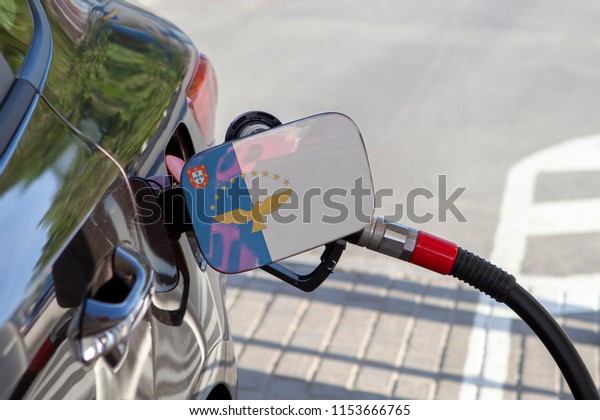 Flag of Azerbaijan on the car\'s fuel\
tank filler flap. Fueling car with petrol pump at a gas station.\
Petrol station. Gasoline and oil products. Close\
up.