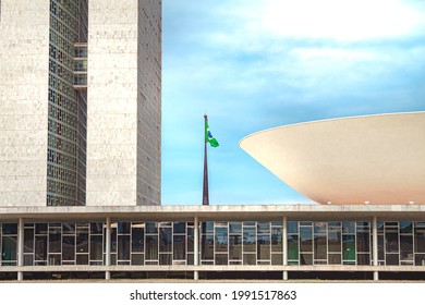 Flag Of Brazil Behind The National Congress Of Brazil. Brazilian Parliament Building - Chamber Of Deputies And Federal Senate. Brasilia, Federal District - Brazil. June 6, 2021.
