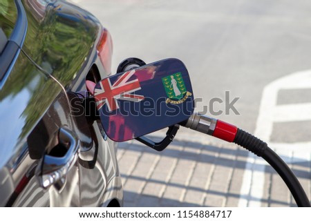 Flag of Brit Virgin Islands on the car's fuel tank filler flap. Fueling car with petrol pump at a gas station. Petrol station. Gasoline and oil products. Close up.