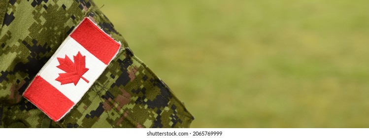 Flag of Canada on soldiers arm. Canadian Armed Forces (CAF). Empty space for text