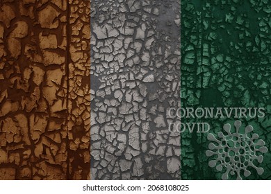 flag of cote divoire on a old vintage metal rusty cracked wall with text coronavirus, covid, and virus picture.