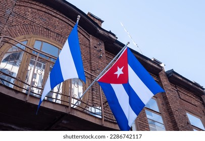 The flag of Cuba on the wall of an old brick house.