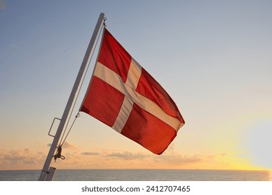 The flag of Denmark waves over the North Sea.