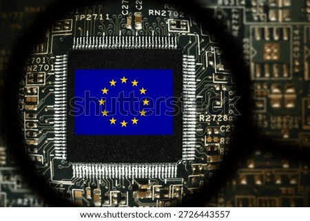 Flag of EU on a processor. Computer board with chip. View through magnifying glass