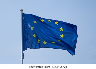 Flag of the European Union isolated on a clear blue sky waving on the wind