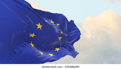 Flag of the European Union waving in the wind on flagpole against the sky with clouds on sunny day - Shutterstock ID 1933686305
