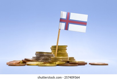 Flag of Faroe Islands in a mixed stack of european coins and a blue background.(series)