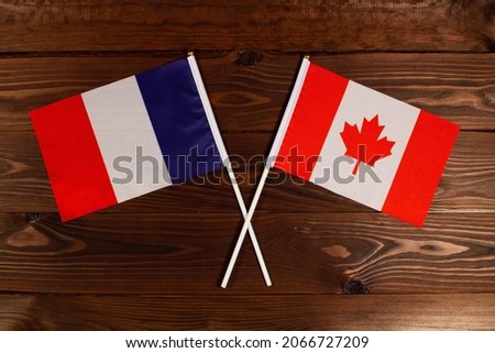 Flag of France and flag of Canada crossed with each other. The image illustrates the relationship between countries. Photography for video news on TV and articles on the Internet and media.