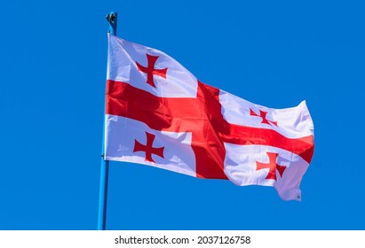The flag of Georgia is a white banner with five red crosses