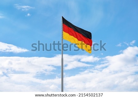 Similar – Waving German flag in front of a blue sky with clouds, Hallig Oland in the background