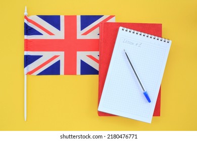 Flag Of Great Britain, Notebook And Textbook On Yellow Background. Travel And Learning Foreign Language. Education Lesson Studying Concept. Flat Composition For English Courses With Space For Text