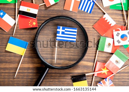 Flag of Greece. Flags of many countries, magnifying glass on wooden table