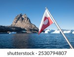 Flag of Greenland. Background with mountains and glaciers. Beautiful sunny day in summer. Greenland