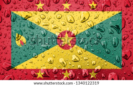 Flag of Grenada on a metallic background. The Grenadian flag with rain droplets