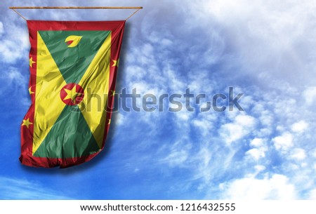Flag of Grenada. Vertical flag, against blue sky with place for your text