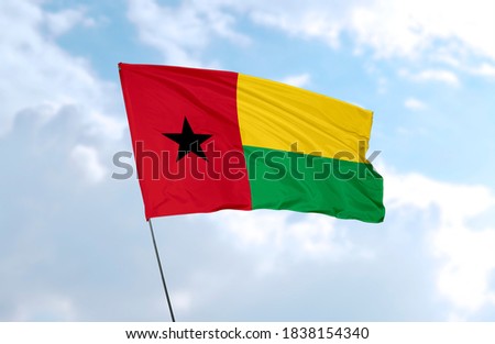 Flag of Guinea-Bissau in front of blue sky