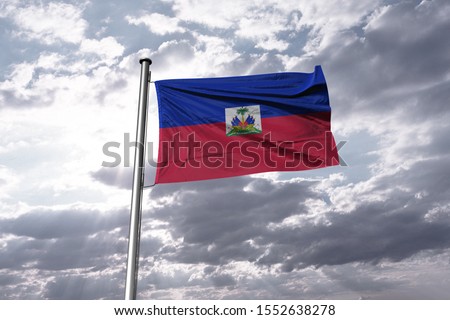 Flag of Haiti waving in the blue sky. National Haiti Flag on Pole.