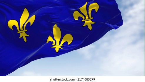 The flag of Ile de France region waving in the wind on a clear day. Ile de France is the most populous of the eighteen regions of France