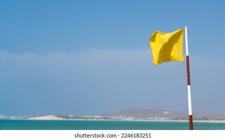 Flag indicating that swimming under curent contitions might be dangerous. Strong winds and big waves - swim at your own risk. Not safe to swim - sign from life guard of the hotel beach. - Powered by Shutterstock