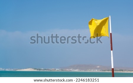 Flag indicating that swimming under curent contitions might be dangerous. Strong winds and big waves - swim at your own risk. Not safe to swim - sign from life guard of the hotel beach.