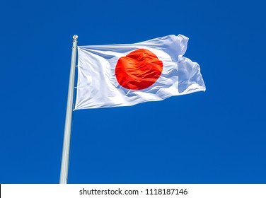 Flag of Japan waving in the wind against the blue sky