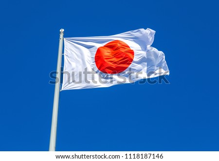 Flag of Japan waving in the wind against the blue sky