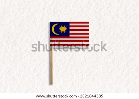 The Flag of Malaysia with Wooden Pole on White Paper.