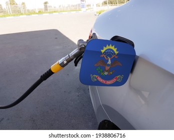 Flag of North Dakota on the car's fuel tank filler flap. Petrol station. Fueling car at a gas station.