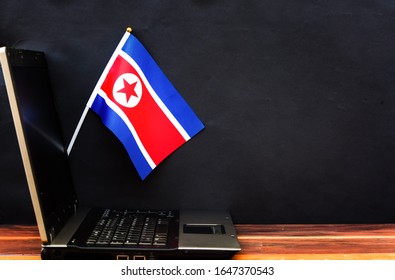 Flag Of North Korea , Computer, Laptop On Table And Dark Background