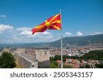 The flag of Northern Macedonia on the fortress of Ohrid. Mountains and city in the background 