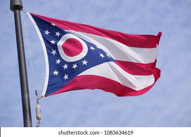Flag of Ohio waving in the wind with blue sky as background closeup