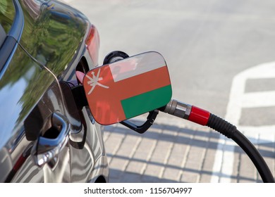 Flag Of Oman On The Car's Fuel Tank Filler Flap. Fueling Car With Petrol Pump At A Gas Station. Petrol Station. Gasoline And Oil Products. Close Up.