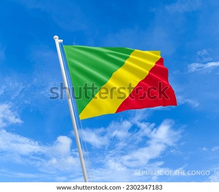 Flag on Congo flag pole and blue sky, Flag of Congo fluttering in blue sky big national symbol. Waving red, yellow and green Congo flag, Independence Constitution Day.