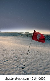 flag on a snow covered links golf course at night in ireland in winter
