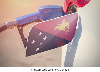 Flag Of Papua New Guinea On The Car's Fuel Filler Flap With Gas Pump Nozzle In The Tank