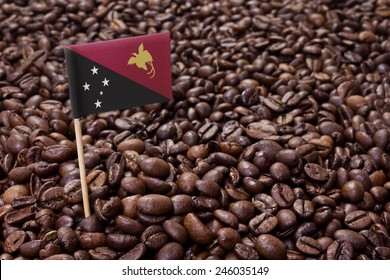 Flag of Papua New Guinea sticking in roasted coffee beans.(series)