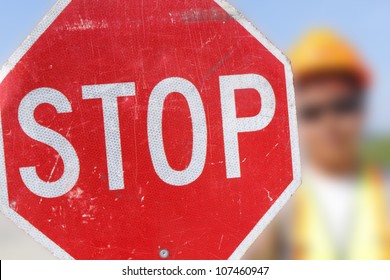 A Flag Person Holds Up A Stop Sign For On-coming Motorists. /Flag Person Holds Stop Sign/A Person Is Assigned To Control Traffic In A Construction Area.