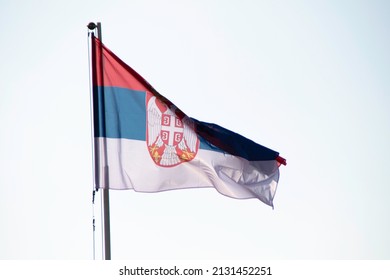 The Flag Of The Republic Of Serbia Flutters In The Wind.