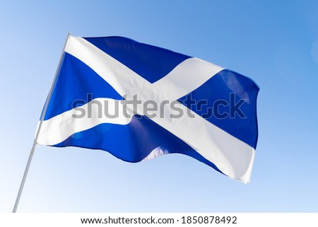 Flag of Scotland waving against blue sky