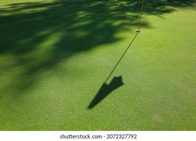 Flag shadow on the golf course with green grass. High quality photo