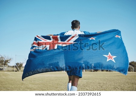 Flag, sports and a man running on a field with a blue sky to celebrate outdoor. Banner, champion and athlete person with patriotism and pride after winning competition to support New Zealand country