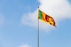 Flag Of Sri Lanka Or The Sinha Flag Is On A Flagpole Under Cloudy Sky On A Sunny Day
