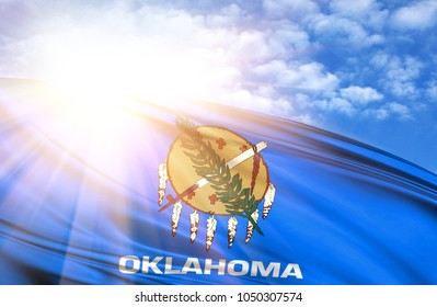 flag of State of Oklahoma against the blue sky with sun rays