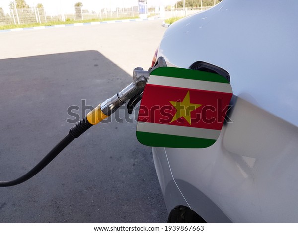 Flag of Suriname on the\
car\'s fuel tank filler flap. Petrol station. Fueling car at a gas\
station.